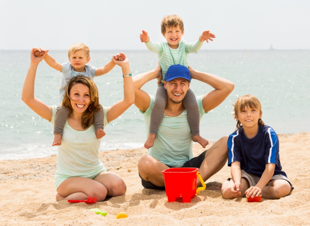 Happy Family with Toddlers smiling at beach